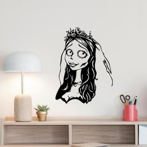 以下が含まれることがあります： 長い髪、ベール、花の冠を持つ花嫁の白黒イラスト。花嫁は大きな目をし、わずかに微笑んでいます。このアートワークは、ゴシックまたはアニメーションアートのファンに最適なウォールデカールです。