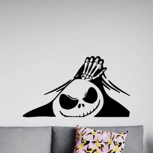 May include: Black and white vinyl decal of Jack Skellington from The Nightmare Before Christmas peeking out from behind a wall. The decal features Jack's signature grin and skeletal hand.