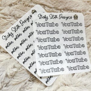 May include: Two sheets of stickers with the text "YouTube" and "Sticky Sloth Designs" in black ink. The stickers are on a textured, off-white background. The word "peloton" is also printed on the stickers.