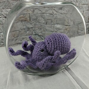 May include: A purple crocheted octopus in a clear glass fishbowl.