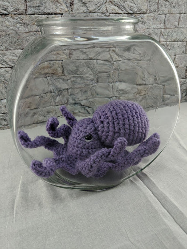 May include: A purple crocheted octopus in a clear glass fishbowl.