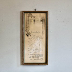 May include: A rectangular framed wall art piece featuring the poem Crossing the Bar by Alfred Tennyson. The print displays a sepia-toned illustration of a window overlooking a calm sea at sunset, with the full text of the poem printed below.