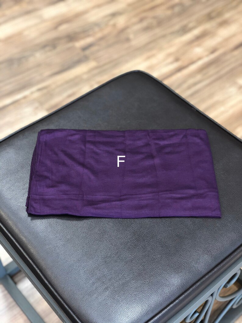 Puede incluir: Un rect&aacute;ngulo de tela morado con la letra "F" impresa en blanco en el centro.