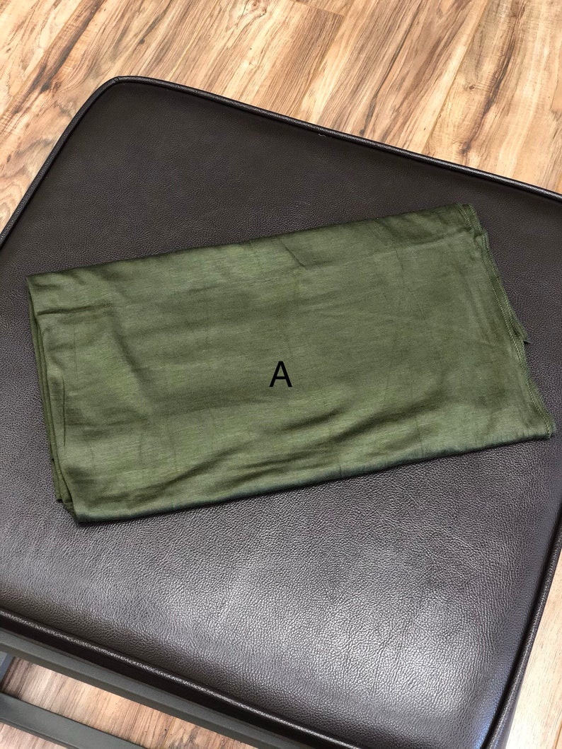 Puede incluir: Un trozo de tela verde doblado con la letra "A" impresa en &eacute;l.