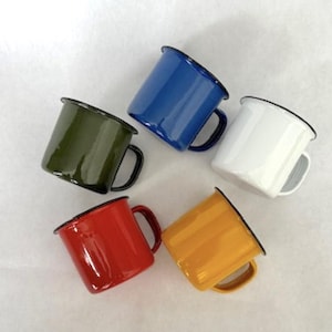 May include: Five enamel mugs in different colors: blue, green, white, red, and yellow. Each mug has a black rim and a handle.