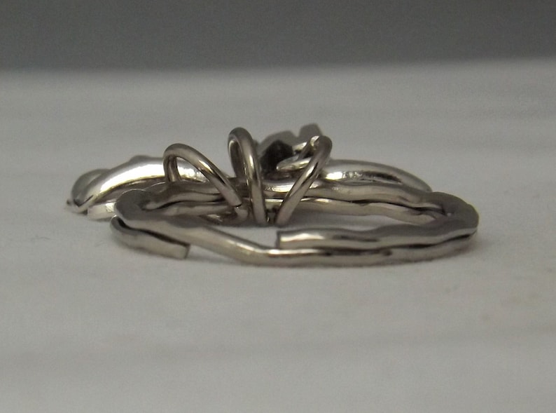 May include: A silver metal key chain with multiple interlocking rings.