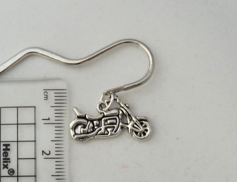 May include: Silver bookmark with a motorcycle charm. The bookmark is approximately 5 cm long and has a hook at the top.