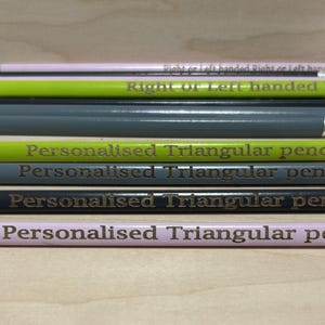 May include: A set of eight pencils with different coloured bodies and silver accents. The pencils are all triangular and have the text "Personalised Triangular pencils" engraved on them.