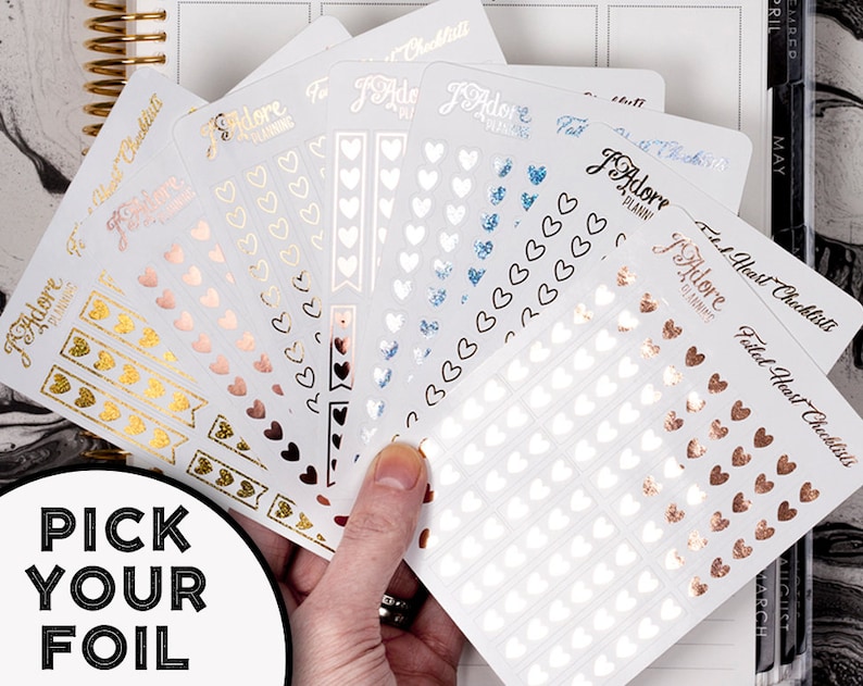 May include: A set of six heart-shaped sticker sheets with different foil finishes. The sheets are labeled "Fitted Heart Checklists" and feature a variety of heart sizes and designs. The foil finishes include gold, rose gold, silver, and blue.