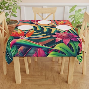 May include: A vibrant tablecloth featuring a tropical floral design with large green leaves, orange, pink, and purple flowers. The tablecloth is set on a wooden table with four white plates. The overall theme is a colorful, botanical design.