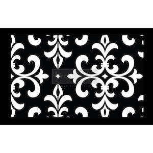 May include: Black and white damask pattern stencil. The stencil features a repeating floral design with scrollwork and fleur-de-lis elements. The words "re-design with prima" and "DIY simplified" are visible on the stencil.