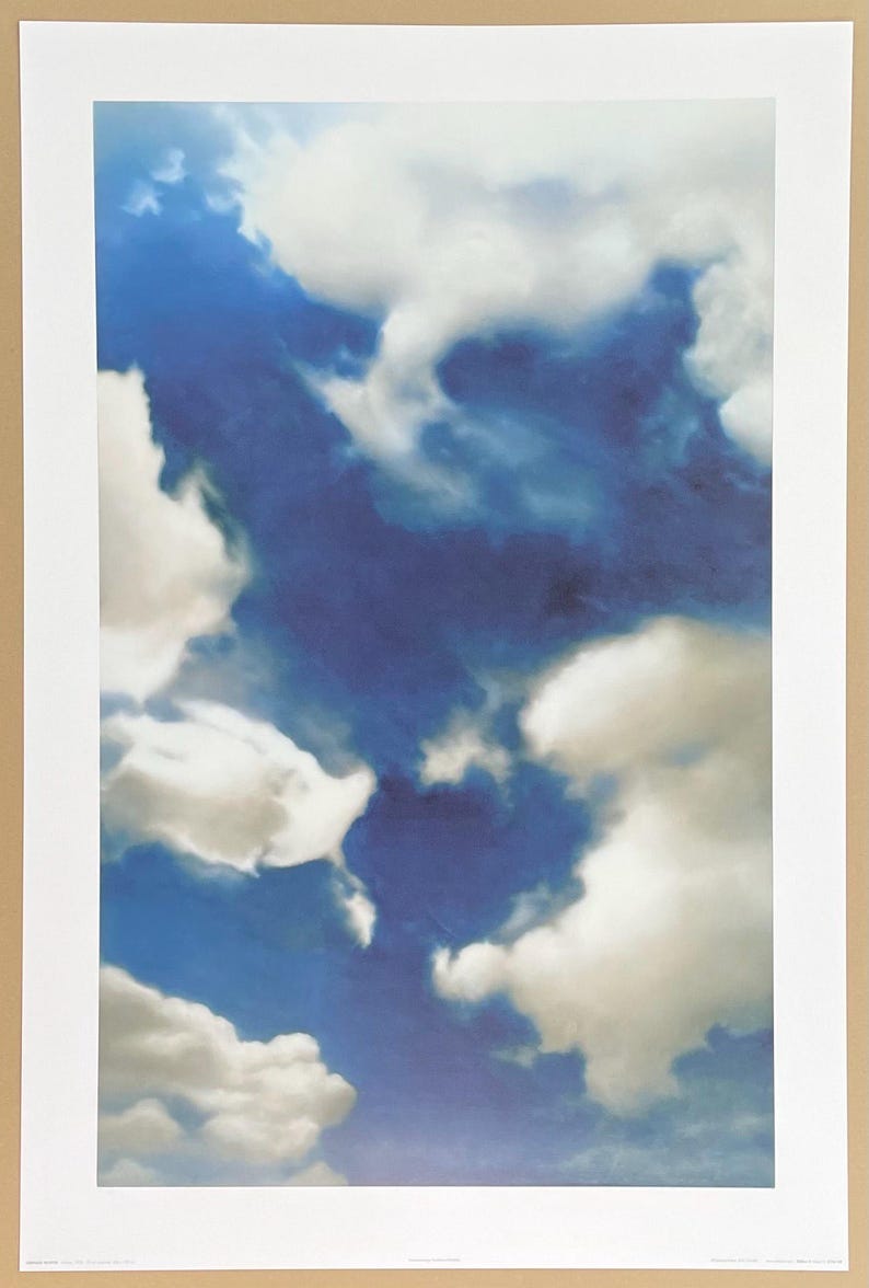 May include: A photograph of a blue sky with white clouds. The clouds are fluffy and appear to be moving across the sky.