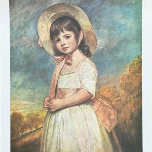 Puede incluir: Una impresión de una niña con un vestido blanco y un sombrero de paja grande, sosteniendo una cinta. La obra de arte tiene un estilo suave y pictórico con una paleta de colores apagados de azules, rosas y amarillos. El fondo representa un paisaje.