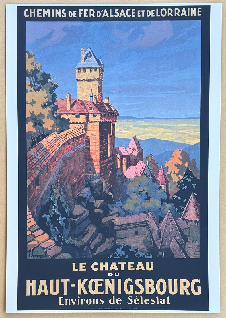 May include: Vintage travel poster for the Chemins de Fer d'Alsace et de Lorraine, featuring Le Chateau du Haut-Koenigsbourg. The poster depicts a detailed illustration of the castle on a hillside, with text at the top and bottom.