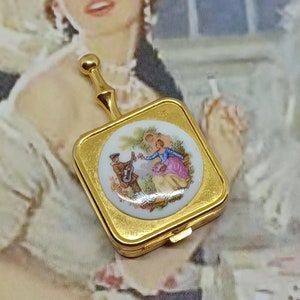 Cendrier de poche avec couvercle à charnière et poignée ~ ton doré avec un couple romantique de la Renaissance sur un disque en céramique ~ cendrier de voyage vintage