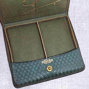 Pu&ograve; includere: Astuccio vintage in pelle verde aperto, che rivela due scomparti. Il lembo anteriore presenta un motivo strutturato. All'interno, la scritta dorata recita "Liz best wishes for 1952". Marchiato "MADE IN STANLEYS ENGLAND".