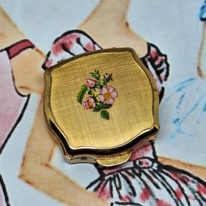 Pastillero Stratton dorado con flores rosas, años 60