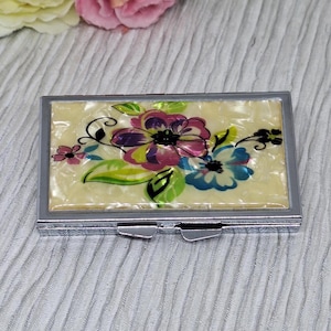 Boîte à pilules argentée avec couvercle en imitation nacre et fleurs roses et bleues ~ Pilulier de 7 jours avec miroir