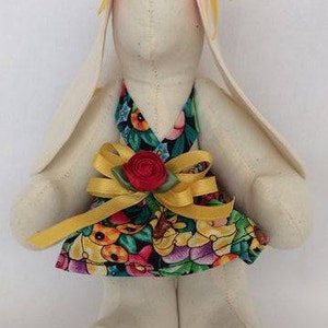 Small handmade bunny rabbit with black print sundress, yellow satin ribbon trim and dark red rosette