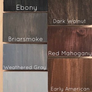 May include: Six wood stain samples in different shades of brown, gray, and black. The samples are labeled with the following names: Ebony, Dark Walnut, Briarsmoke, Red Mahogany, Weathered Gray, and Sunbleached.