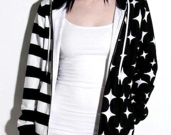 May include: A zip-up hoodie featuring a split design with horizontal black and white stripes on the right side and a black fabric with a white four-pointed star pattern on the left side, complete with a hood and white drawstring cords.