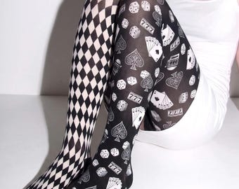 May include: A pair of mismatched tights featuring a black and white diamond harlequin pattern on one leg and a black background with white casino-themed graphics including dice, playing cards, and the number 777 on the other leg.