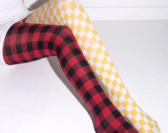 May include: A pair of mismatched tights featuring a bold buffalo plaid pattern in red and black on one leg and a vibrant yellow and white checkerboard pattern on the other leg. The hosiery is opaque and covers the legs from the hip to the toes.