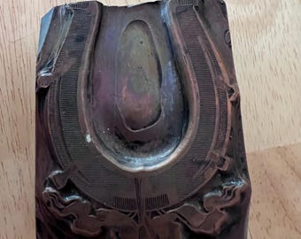 Antique letterpress printing block. All metal with slots on back.  Horseshoe