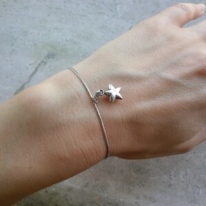 May include: A silver chain bracelet with a star charm.