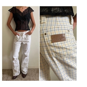 K&ouml;nnte beinhalten: Wei&szlig;e und gelbe karierte Wrangler-Hose mit einem braunen Leder-Patch auf der Ges&auml;&szlig;tasche.