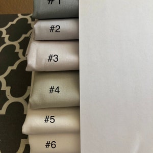 May include: Six fabric swatches in different shades of grey, numbered 1 through 6.