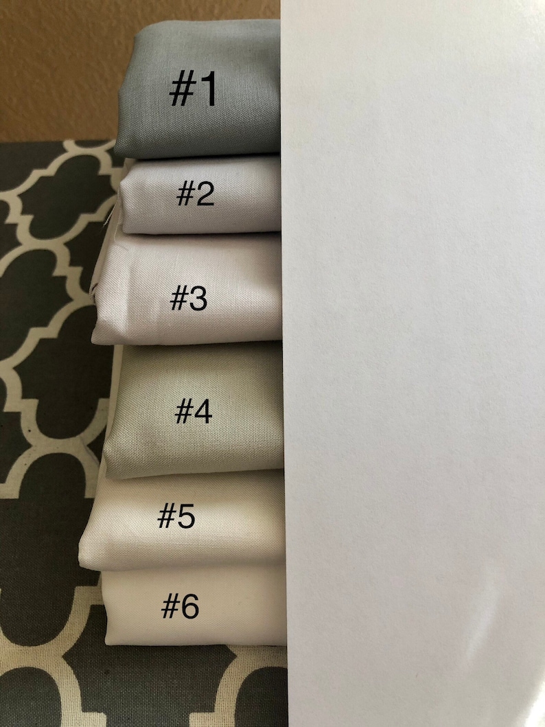 May include: Six fabric swatches in different shades of grey, numbered 1 through 6.