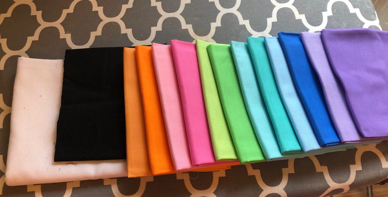May include: A collection of 12 fabric swatches in various colours, including white, black, orange, pink, hot pink, lime green, light blue, sky blue, royal blue, lavender, and purple.