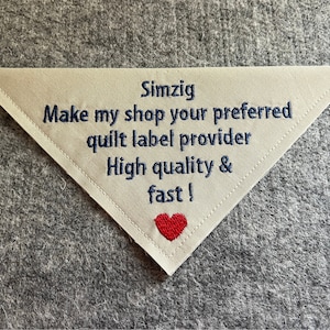 May include: White triangular fabric label with blue embroidered text that reads "Simzig Make my shop your preferred quilt label provider High quality & fast!" with a red heart at the bottom.