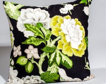 May include: Black pillow with a floral pattern featuring white, yellow, and green flowers. The pillow is made of a soft, linen fabric.