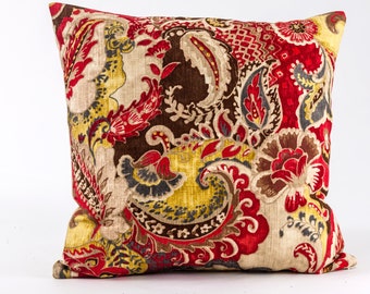 May include: A decorative throw pillow with a paisley pattern in shades of red, brown, yellow, and cream.