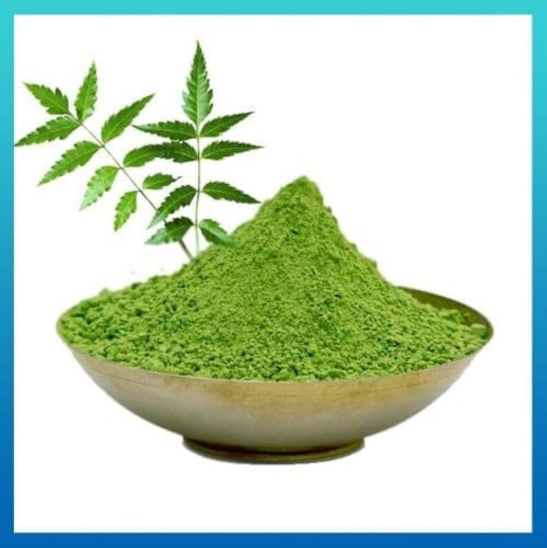 May include: A bowl of green neem powder with a neem leaf sprig on the side.