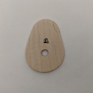 May include: A light wood, teardrop-shaped, wooden tool with a hole in the centre and a small bicycle logo.