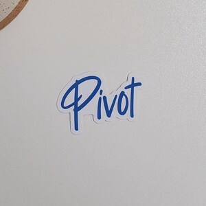 May include: A white sticker with the word "Pivot" written in blue cursive lettering.