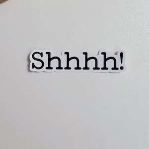 May include: White sticker with the text "Shhhh!" in black lettering on a white background.