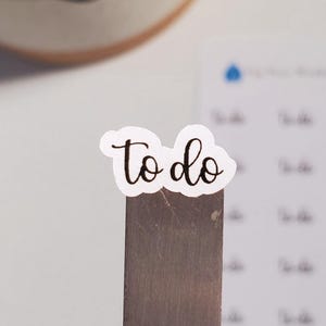 May include: White sticker with the word "to do" written in brown cursive.