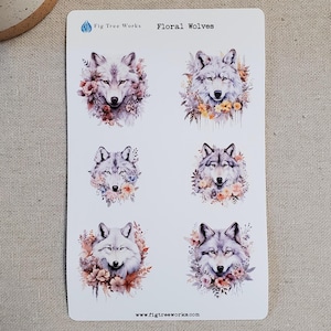 May include: A sheet of six stickers featuring watercolor illustrations of wolf faces surrounded by floral designs. The stickers are white with a light blue logo that says "Fig Tree Works" and the text "Floral Wolves".