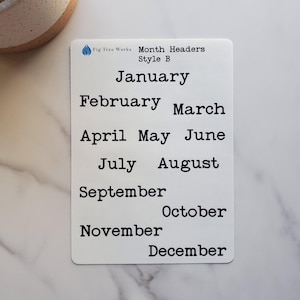May include: A white rectangular card with the text "Month Headers Style B" and the months of the year in black font. The card is on a white marble surface.