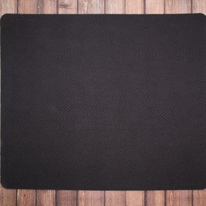 May include: A black mouse pad with a textured surface.