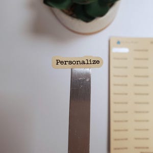 May include: A brown paper sticker with the word "Personalize" printed in black text.