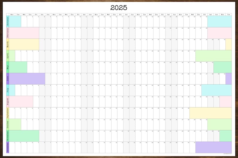 May include: A printable 2025 calendar with a wooden frame. The calendar is divided into 12 months, with each month represented by a different color. The colors are: January - light blue, February - pink, March - yellow, April - light green, May - green, June - purple, July - light blue, August - pink, September - yellow, October - light green, November - green, December - purple.
