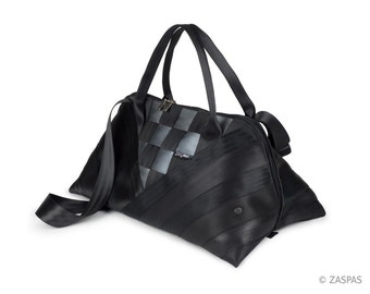 Può includere: Borsa da viaggio nera realizzata con cinture di sicurezza riciclate. La borsa ha un motivo a scacchi sul davanti e una tracolla nera.