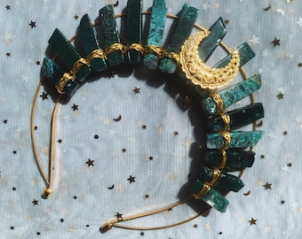 May include: A gold headband with a crescent moon charm and green agate stones wrapped in gold wire.