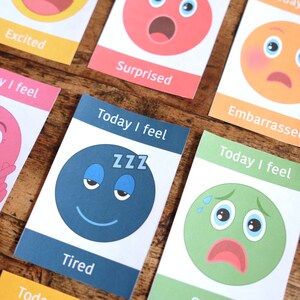 May include: A set of colourful cards with different facial expressions and the text "Today I feel" and the emotion word. The cards feature a tired face with the text "ZZZ" and the word "Tired".