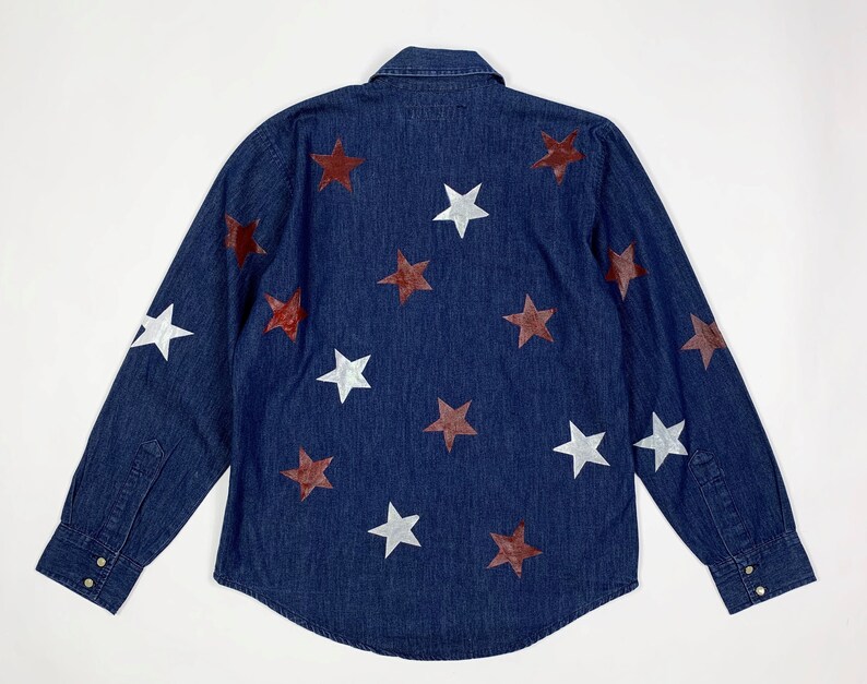 K&ouml;nnte beinhalten: Ein dunkelblaues Jeanshemd mit langen &Auml;rmeln, Knopfleiste und einem Muster aus wei&szlig;en und kastanienbraunen Sternen.